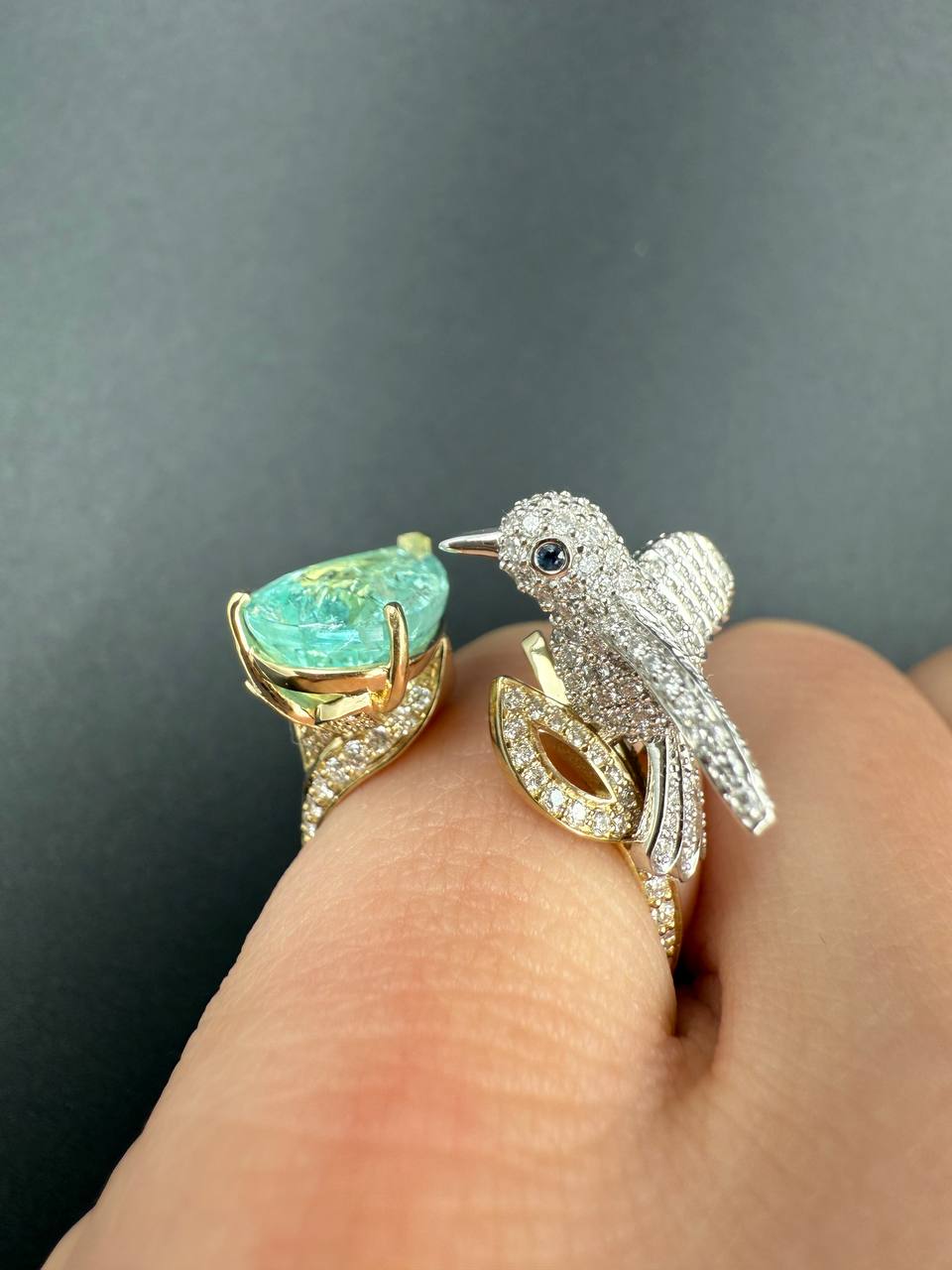 Paraíba tourmaline ring with a diamond bird facing the pear-shaped stone