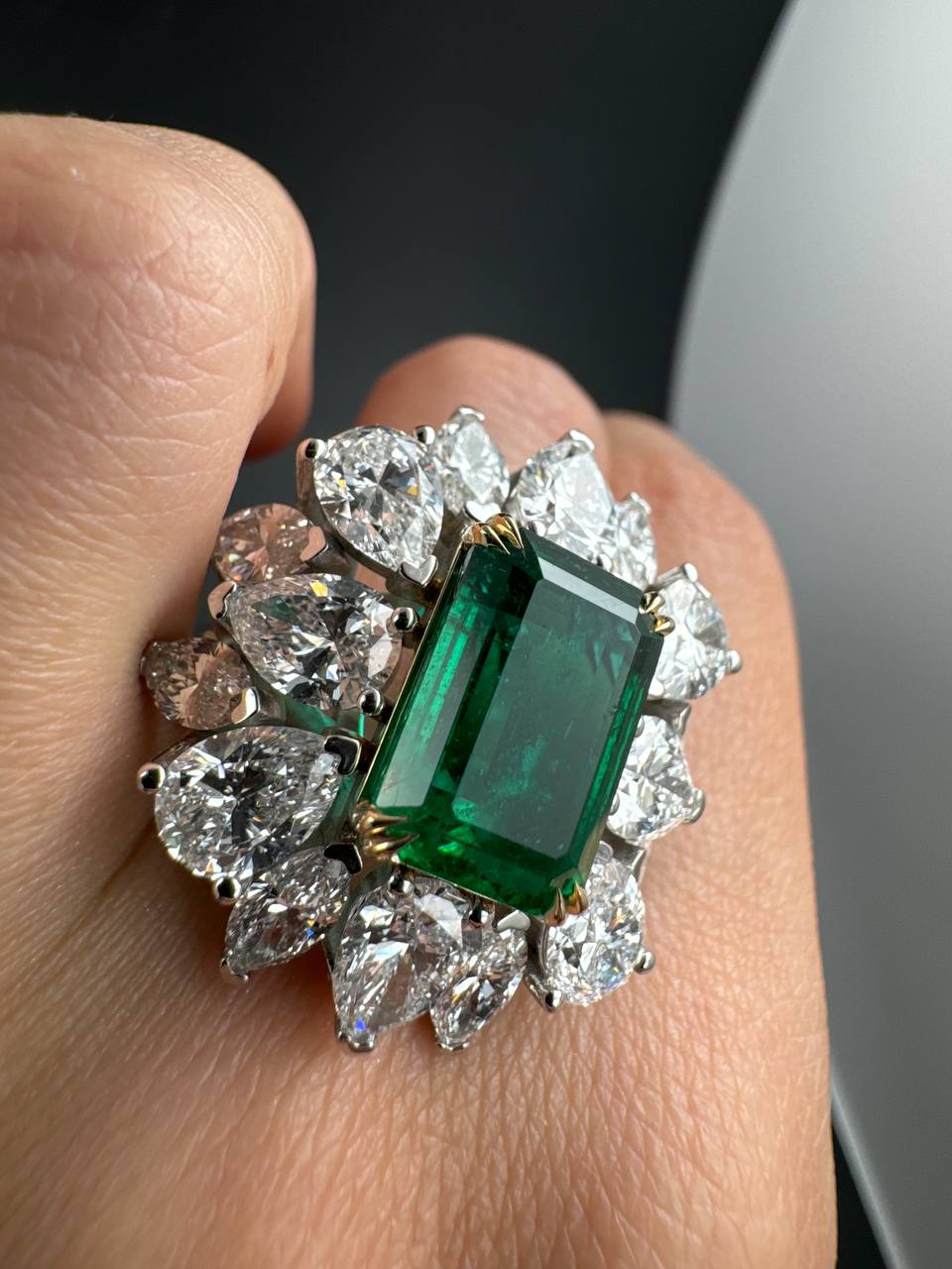Close view of the emerald and diamond halo, front angle