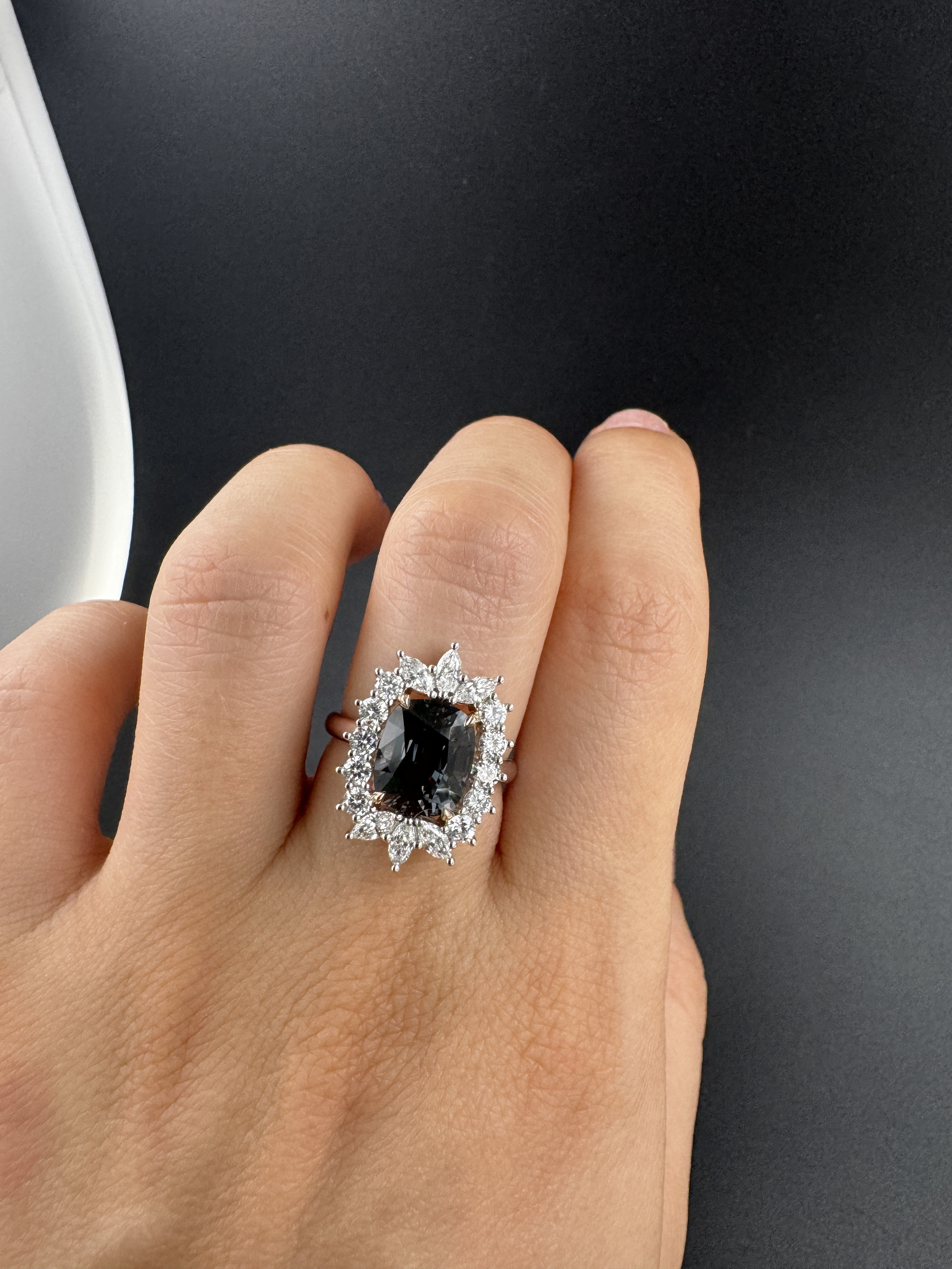 Colour-change grey spinel ring with a diamond halo on the hand