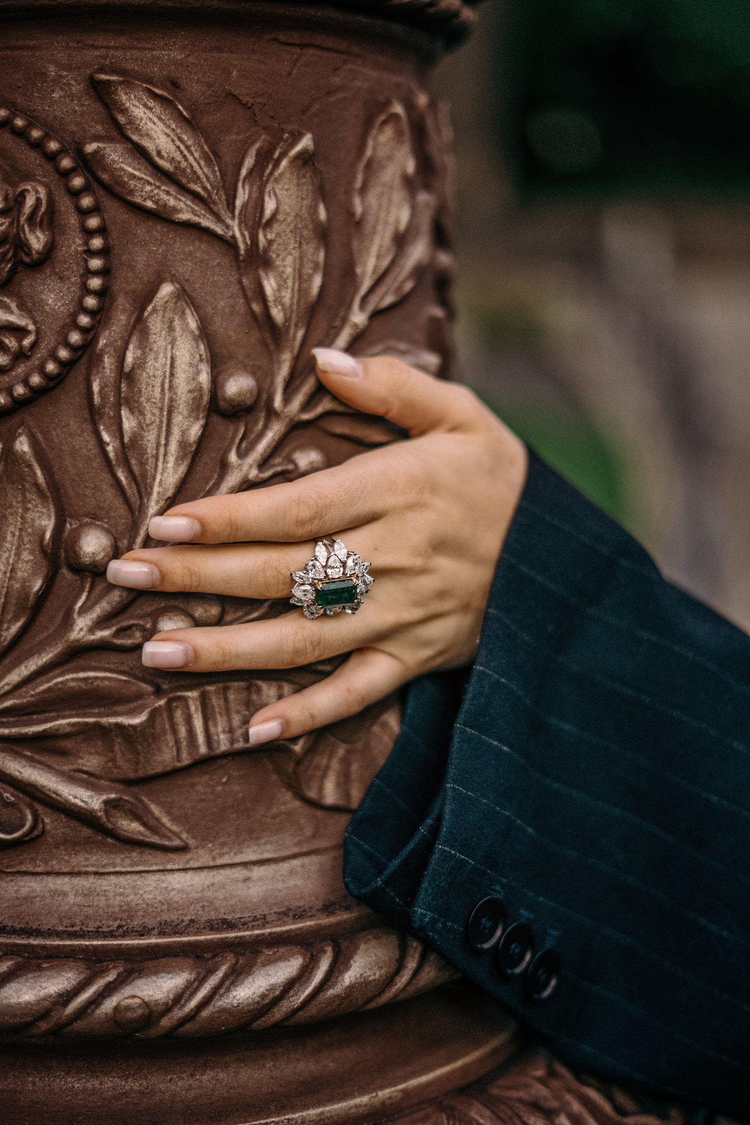 Hand wearing a natural emerald and diamond ring